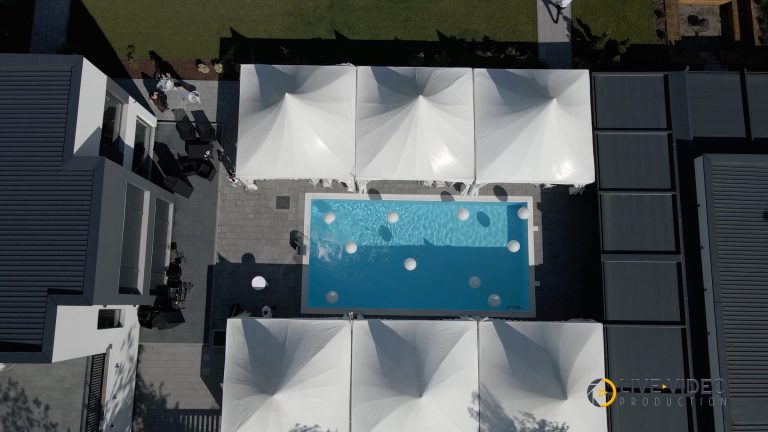 Outdoor party by a pool, filmed from above with a drone
