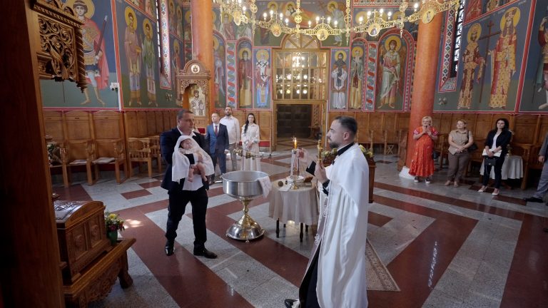 Obred krštenja u crkvi: beba, sveštenik i porodica kod krstionice